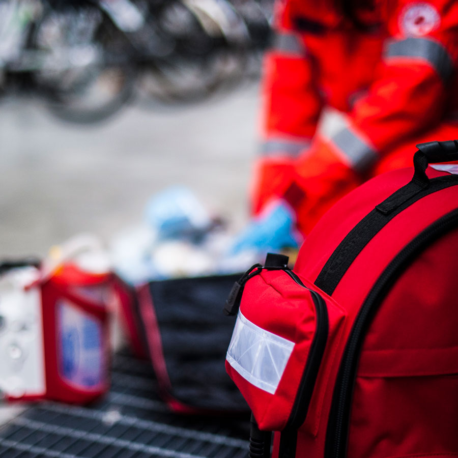 CPR Boston - First Aid Kit on the ground with first responder blurred out in the background